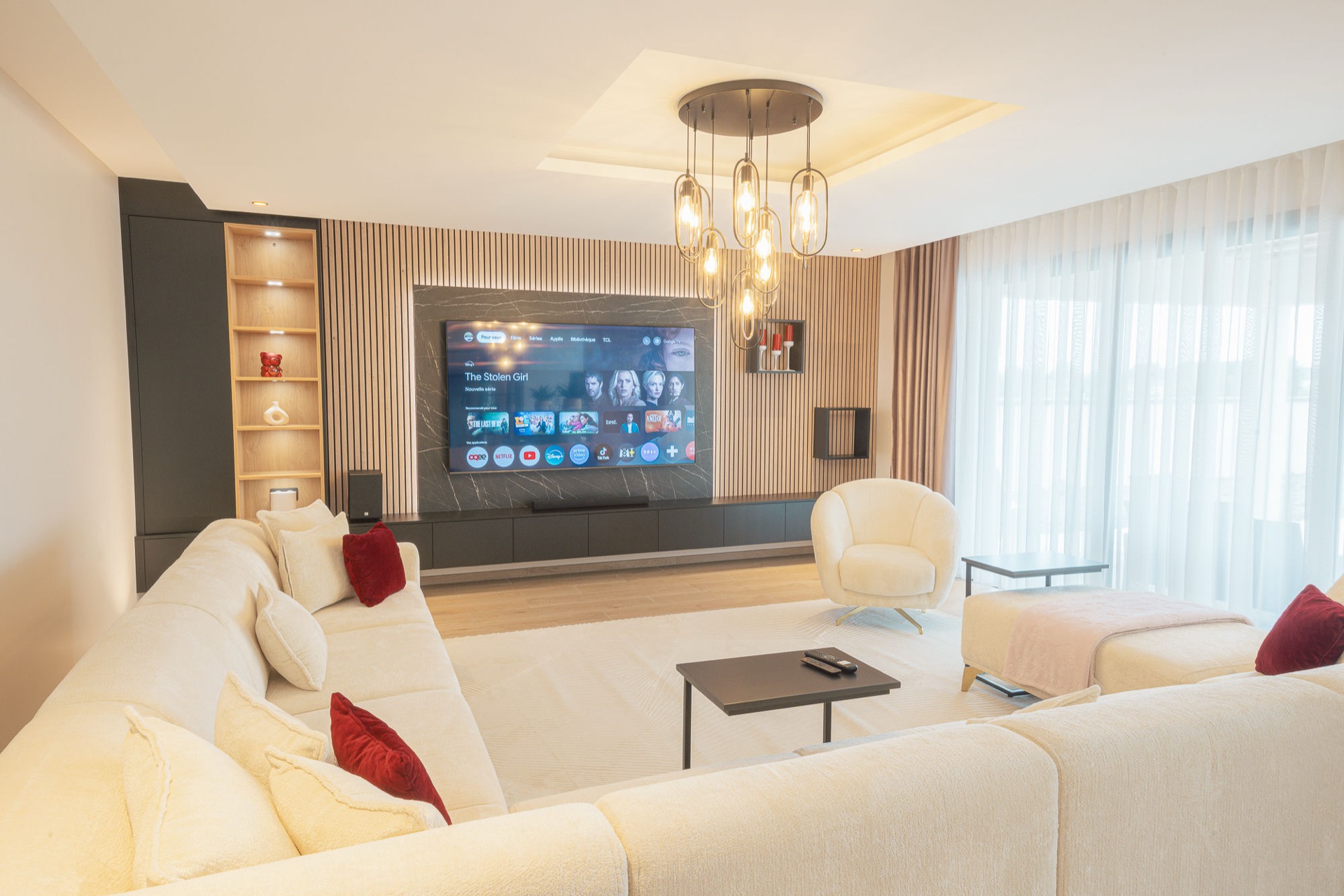 Aménagement sur mesure d’un salon avec habillage mural et meuble TV en bois